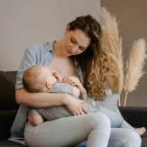 Jonge mama geeft borstvoeding aan baby