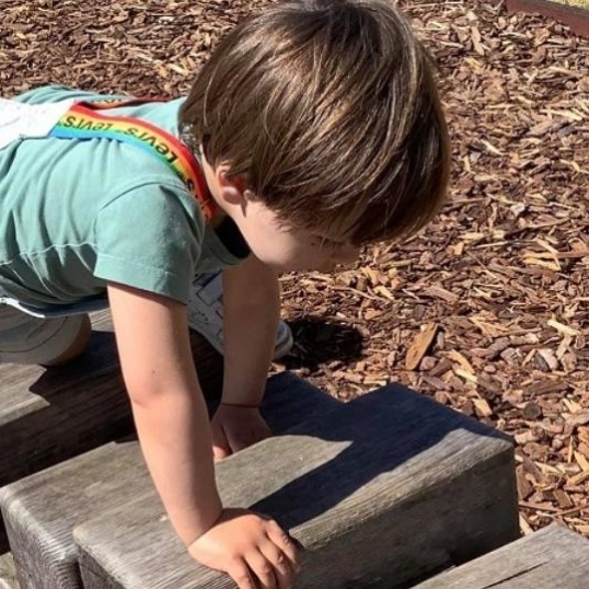 peuters klimmen op houten balken als onderdeel van risicovol spel